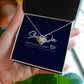 A hand holds a luxury box and knot necklace on a message card